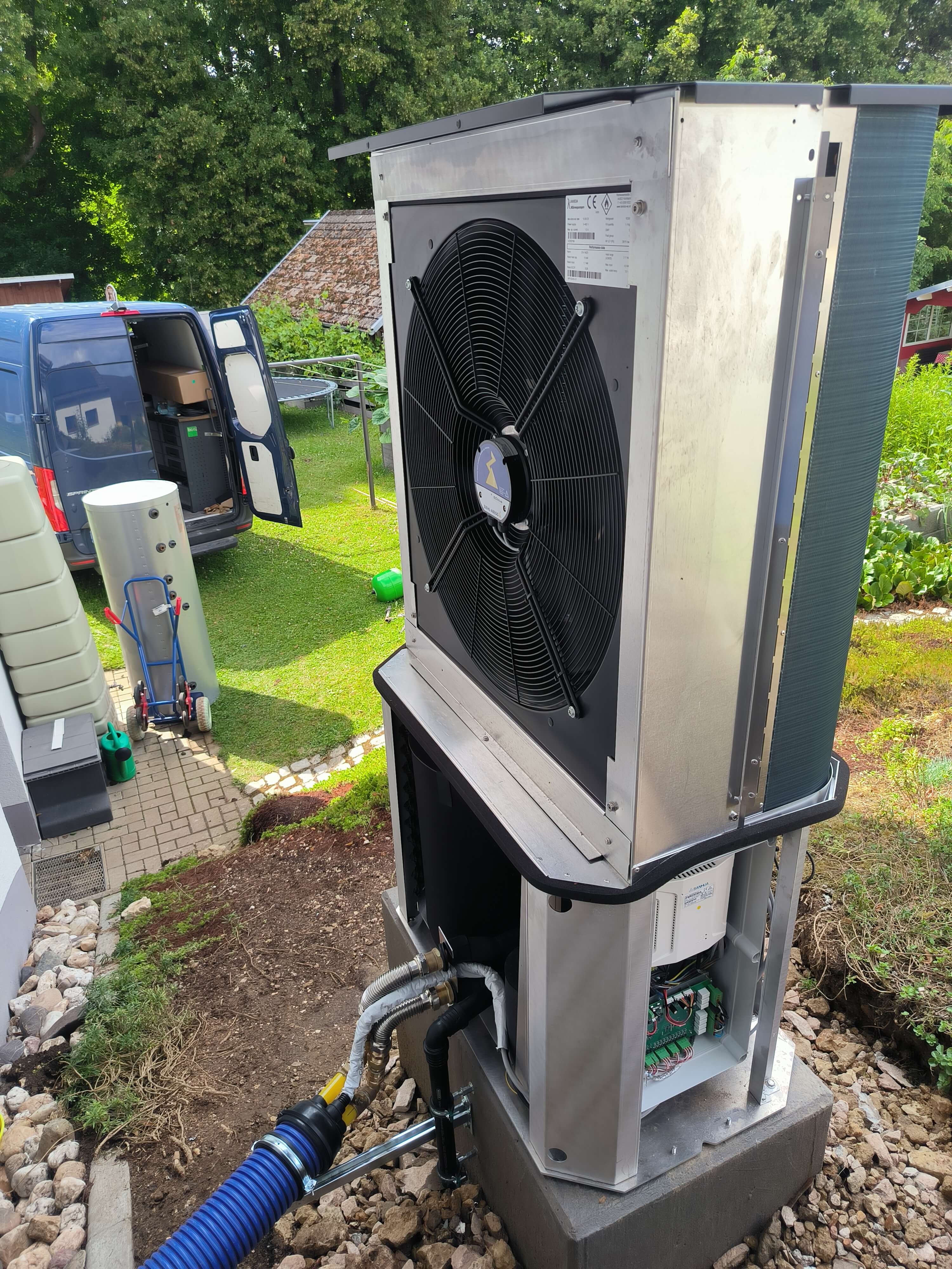 Moderne Wärmepumpe im Garten installiert für effiziente Heizung Die Installation einer Wärmepumpe im Freien zeigt die technischen Details unter der Verkleidung.